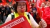 A supporter of the Confederation of German Trade Unions (DGB) blows a whistle as she takes part in a union rally for "political change" in Frankfurt, Sept. 7, 2013. 