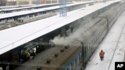 Seorang pekerja melintas di depan kereta di stasiun di Kyiv, Ukraina, 12 Januari 2017.