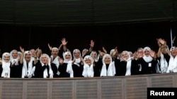 FILE - Supporters of Turkey's Prime Minister Tayyip Erdogan (not pictured) cheer as he addresses the members of parliament from his ruling AK Party (AKP) during a meeting at Turkish parliament in Ankara. 