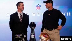 San Francisco 49ers head coach Jim Harbaugh (R) and his brother, Baltimore Ravens head coach John Harbaugh, appear at their joint press conference and stand next to the Vince Lombardi trophy ahead of the NFL's Super Bowl XLVII in New Orleans, Louisiana, F