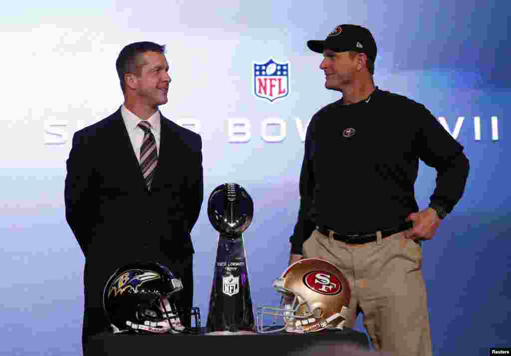 Kepala pelatih San Francisco 49ers Jim Harbaugh (kanan) dan saudara laki-lakinya, kepala pelatih Baltimore Ravens John Harbaugh, dalam konferensi pers gabungan dan berdiri dekat piala Vince Lombardi sebelum final NFL Super Bowl XLVII di New Orleans, Louisiana (1/2).