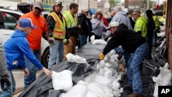 Volunteers place sandbags to protect buildings from potential floodwater, May 1, 2017, in Eureka, Mo.