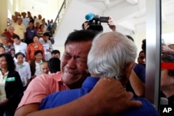 Cambodian former Khmer Rouge survivors, Soum Rithy, left, and Chum Mey, right, embrace each other after the verdicts were announced at the U.N.-backed war crimes tribunal in Phnom Penh, Cambodia, Aug. 7, 2014.