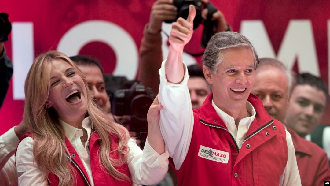 Alfredo Del Mazo, Mexico state gubernatorial candidate for the ruling Institutional Revolutionary Party, or PRI, and his wife Fernanda Castillo greet supporters at the party's headquarters in Toluca, capital of Mexico state, June 4, 2017
