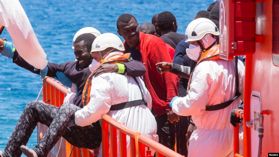 Arhiva - Migrantu, koji je deo grupe od 58 presretnutih na trošnom brodu na oko 100 milja od obale, pomažu spasioci nakon pšto je stigao u luku Arguineguin, Španija, 30. maja 2016.
