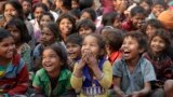 Impoverished Indian children watch a performance that's part of advocacy against child labor, in Allahabad.