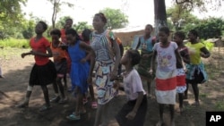 FILE - In this photo taken on April 20, 2018 in the Gorongosa National Park, Mozambique, girls dance as part of a girls' club program that aims to help girls stay in school longer and stay out of child marriage. 