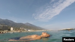 Víctor flota en el mar mientras el pasa el día en Playa Coral, La Guaira, cerca de Caracas, Venezuela. Marzo 23, 2019. REUTERS/Ivan Alvarado.