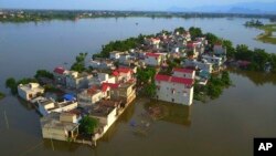 In this photo taken on July 22, 2018, a village is submerged in flood water in the suburb of Hanoi, Vietnam. (Vietnam News Agency via AP)
