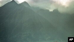 FILE - Seen from adjacent farmland, an afternoon shower rolls in over the volcanic mountains of Congo's Virunga National Park, home the most of the world's last remaining mountain gorillas, Sept. 23, 1997. 