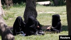 FILE - Veiled women sit in a garden in the northern province of Raqqa, Syria, March 31, 2014. The Islamic State has imposed strict new dress codes on women. 