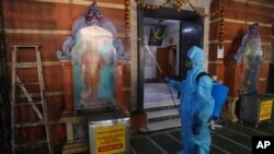 Un empleado desinfecta un templo hindú en Mumbai, India, el domingo 15 de noviembre de 2020. India es el segundo país en el mundo con más casos de coronavirus, detras de EE. UU.