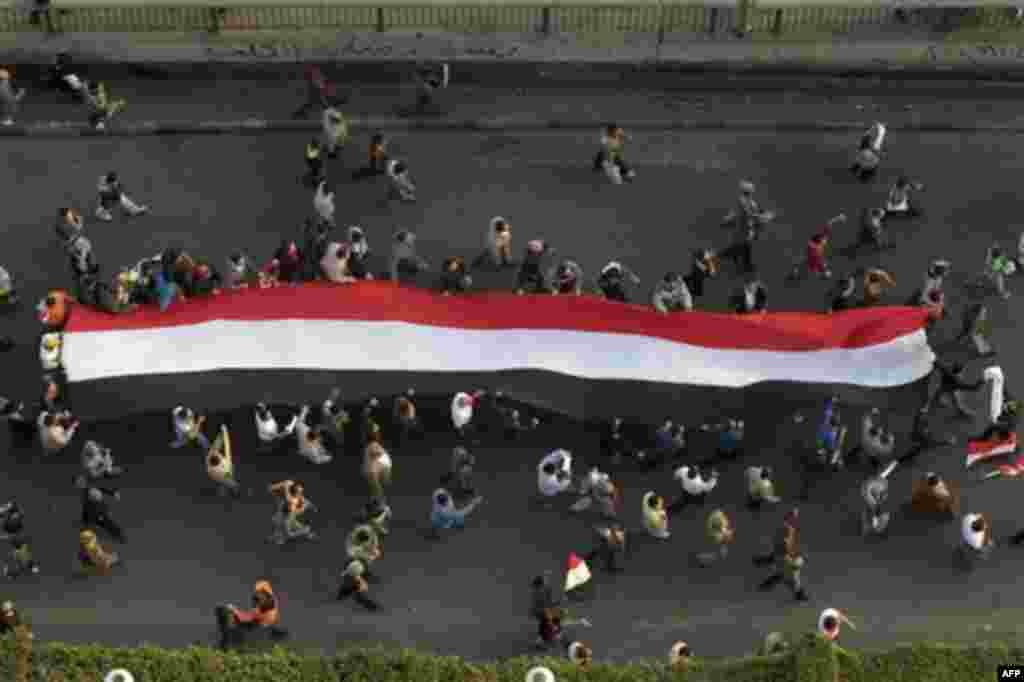 Demonstrators carry a huge flag in Tahrir, or Liberation, Square in Cairo, Egypt, Tuesday, Feb. 1, 2011. More than a quarter-million people flooded into the heart of Cairo Tuesday, filling the city's main square in by far the largest demonstration in a we