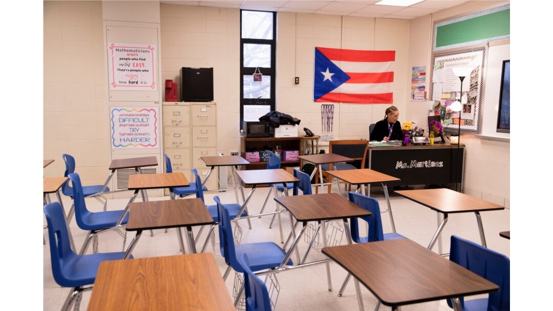 Ms. Martinez, seorang guru di Iroquois High School, berpindah-pindah antara kelasnya dan kelas anak-anaknya selama hari pembelajaran virtual. (Foto: Reuters)