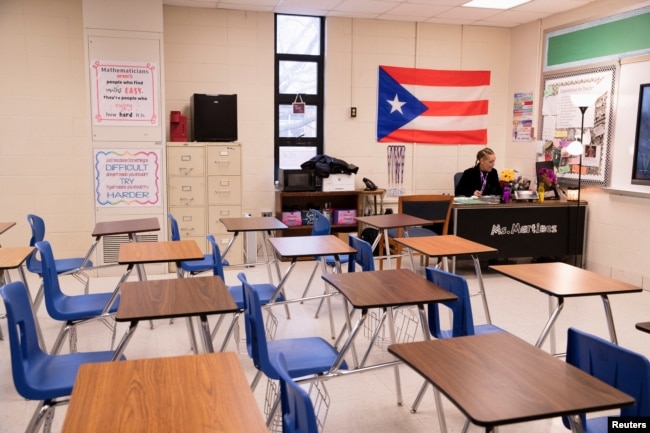 Ms. Martinez, seorang guru di Iroquois High School, berpindah-pindah antara kelasnya dan kelas anak-anaknya selama hari pembelajaran virtual. (Foto: Reuters)