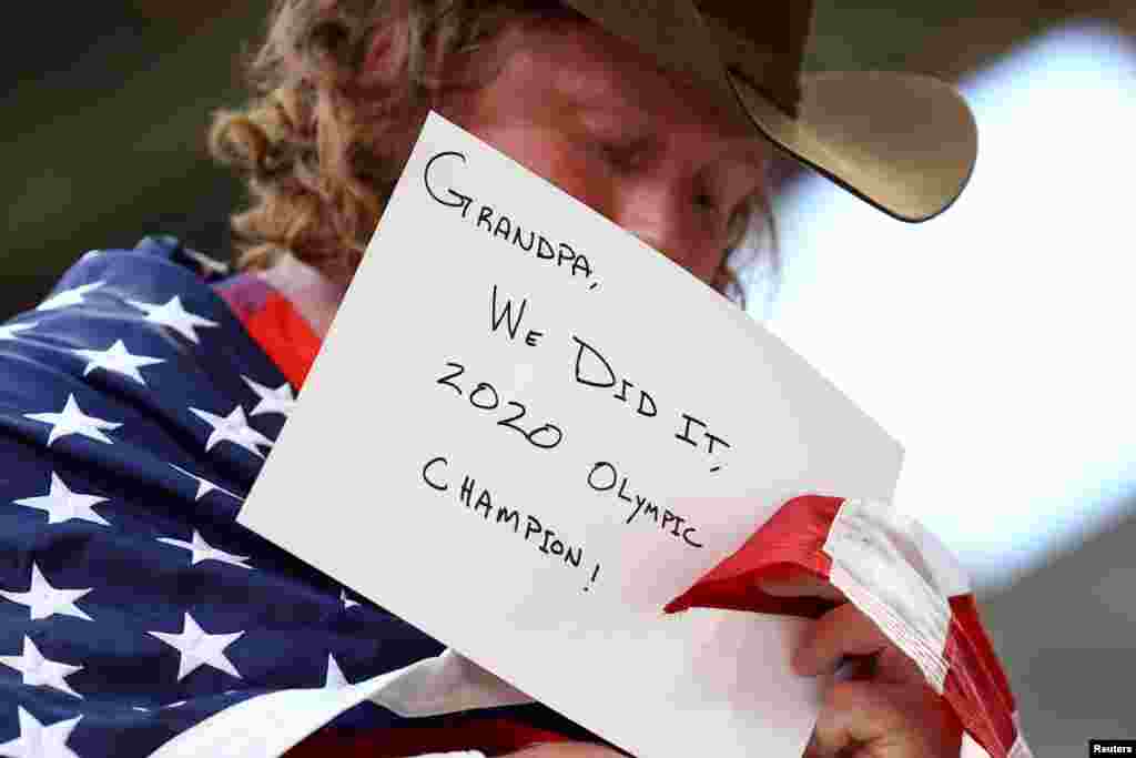 Ryan Crouser of the United States holds a message for his grandfather after winning the gold medal in the men&#39;s shot put final at the 2020 Tokyo Olympics.