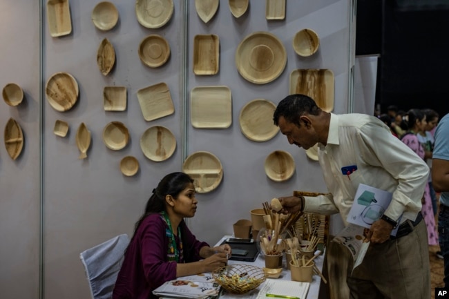 A visitor asks about eco-friendly products at an event to create awareness about eco-friendly products in New Delhi, India on July 1, 2022. (AP Photo/Altaf Qadri)