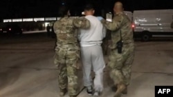 This screenshot from video provided by the U.S. Department of Defense shows the first plane of detained migrants arriving at Naval Station Guantanamo Bay, Feb. 4, 2025.