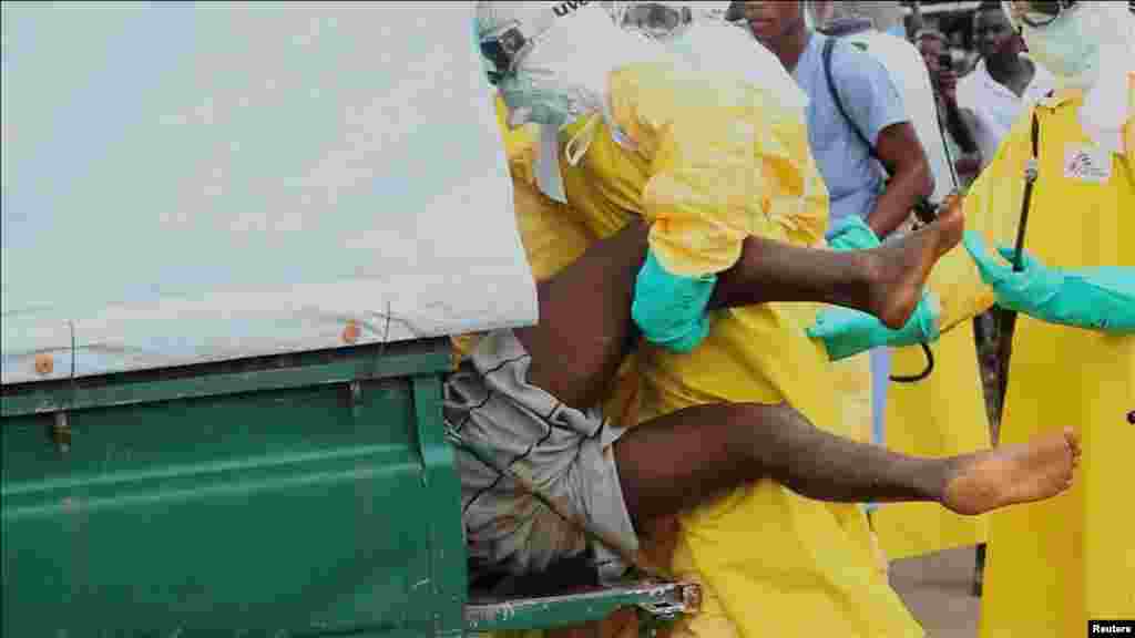 Health workers capture an Ebola patient who escaped from quarantine at the Elwa Hospital, Paynesville, Liberia, Sept. 1, 2014.