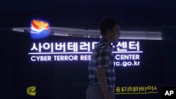 FILE - A man walks by a sign at Cyber Terror Response Center of National Police Agency in Seoul, South Korea, July 16, 2013. North Korea is accused of using cyberattacks against South Korea and 16 other countries to benefit its nuclear program.