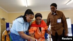 Umwe mu bagize umurwi w'igihugu utunganya amatora muri Afurika y'Epfo ariko afasha umusaza w'impumyi gutora