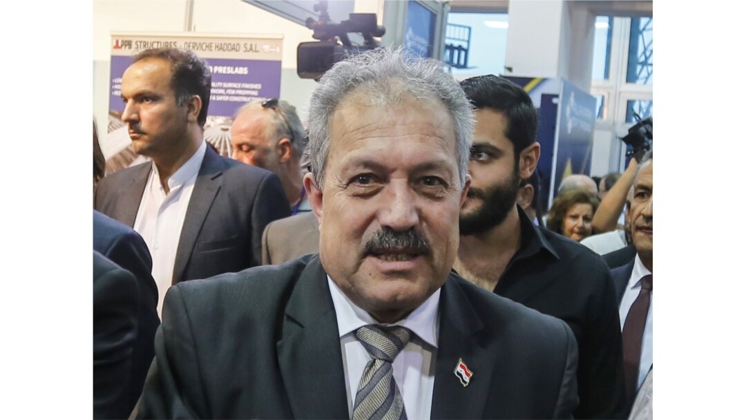 FILE - Syria's then-Water Resources Minister Hussein Arnous attends a trade show in Damascus, Oct. 2, 2018. Syrian President Bashar al-Assad on June 11, 2020, named Arnous interim prime minister.