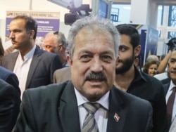 FILE - Syria's then-Water Resources Minister Hussein Arnous attends a trade show in Damascus, Oct. 2, 2018. Syrian President Bashar al-Assad on June 11, 2020, named Arnous interim prime minister.