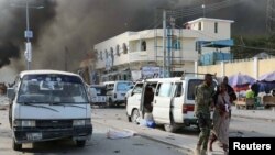 Tentara Somalia membantu mengevakuasi seorang perempuan yang terluka akibat ledakan bom di jalan KM14 di distrik Hodan, Mogadishu, Somalia, 14 Oktober 2017.