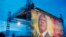 Men prepare stage for campaign rally beside poster for Malian presidential candidate Ibrahim Boubacar Keita, Bamako, Aug. 9, 2013.
