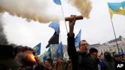 Members of the nationalist movement Svoboda (Freedom) hold flares during a rally marking the 74th anniversary of the Ukrainian Insurgent Army in Kyiv, Ukraine, Oct. 14, 2016. Ukraine celebrates Defenders Day yearly.