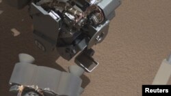 Curiosity muestra una cucharada llena de arena y el polvo levantado por el primer uso del sofisticado rover. 