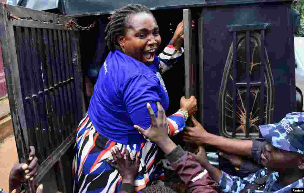 Ugandan police officers detain a supporter of opposition leader Kizza Besigye, who was abducted in neighboring Kenya on Nov. 16, during a march to the Kenya High Commission in Uganda, in Kampala.