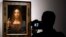 FILE - A visitor films Leonardo da Vinci's "Salvator Mundi" on display at Christie's auction rooms, in London, Oct. 24, 2017. 