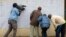 A television cameraman films Kenyans checking if their names are on the electoral lists at a polling station in the Kibera slum in Nairobi, Kenya, Aug. 7, 2017. Kenyans are due to go to the polls on Aug. 8, to vote in presidential elections after a tightly-fought race between President Uhuru Kenyatta and main opposition leader Raila Odinga.