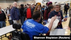 Timothy Boytor, chef de bureau de vote au lycée Cheyenne High School, dirige les électeurs lors du caucus du Nevada, à North Las Vegas, le 22 février 2020. (REUTERS/Shannon Stapleton)