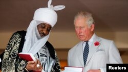 FILE - Britain's Prince Charles stands with the Emir of Kano Lamido Sanusi as they look at a book during his meeting with Traditional Leaders at the British High Commission residence in Abuja, Nov. 6, 2018. 
