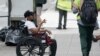 Un hombre en silla de ruedas pide dinero a transeúntes en Manhattan, Nueva York, 7 de agosto de 2020.