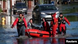 Tim penyelamat mengevakuasi warga yang terjebak banjir di Mamaroneck, negara bagian New York (2/9). 