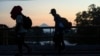 With the Tajumulco Volcano in the background, migrants walk along the Huixtla highway in southern Mexico, Nov. 6, 2024, hoping to reach the country's northern border and ultimately the United States. 