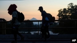 With the Tajumulco Volcano in the background, migrants walk along the Huixtla highway in southern Mexico, Nov. 6, 2024, hoping to reach the country's northern border and ultimately the United States. 