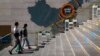 A family walks by a map showing Evergrande development projects in China at an Evergrande city plaza in Beijing, Sept. 21, 2021.