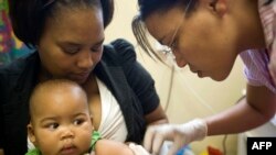 Un enfant se fait vacciner dans un centre contre la tuberculose, en Afrique du Sud, le 27 janvier 2011. (AFP PHOTO/RODGER BOSCH)