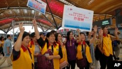 Tourists pose for a photograph at the departure hall of the China-Zhuhai-Macau-Hong Kong Bridge during the first day operation of the world's longest cross-sea project, which has a total length of 55 kilometers (34 miles), in Hong Kong, Oct. 24, 2018. 