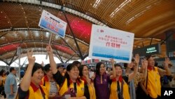 Tourists pose for a photograph at the departure hall of the China-Zhuhai-Macau-Hong Kong Bridge during the first day operation of the world's longest cross-sea project, which has a total length of 55 kilometers (34 miles), in Hong Kong, Oct. 24, 2018. 