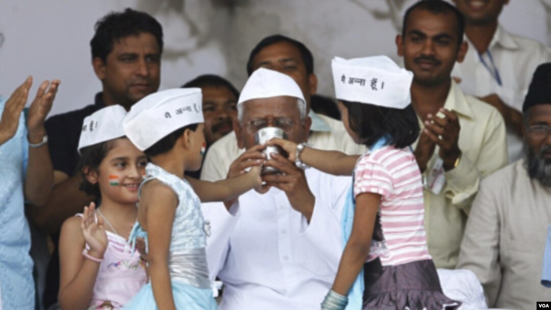 Anak-anak India mengenakan topi tradisional bertuliskan 'I am Anna', menyuguhkan air kelapa dan madu untuk Anna Hazare setelah aktifis itu mengakhiri aksi mogok makannya (28/8).