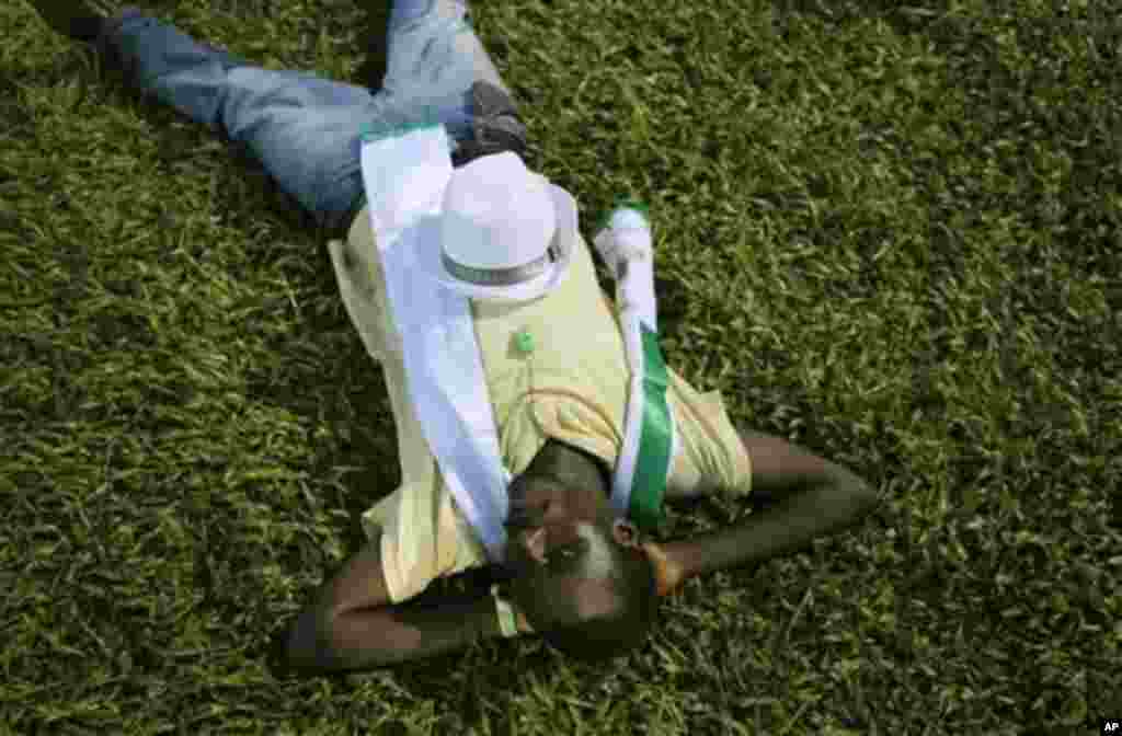 A supporter of opposition candidate Julius Maada Bio naps under stadium lights at rally, Freetown, Sierra Leone, Nov. 15, 2012.