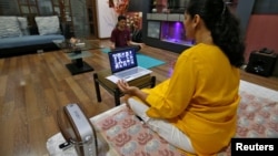 Yoga often involves deep breathing. In Ahmedabad, India, a woman takes an online yoga class in her house on International Yoga Day during the coronavirus outbreak, June 21, 2020. (Reuters Photo/Amit Dave)