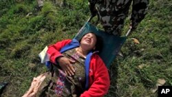 A woman, injured in Saturday’s earthquake, is carried on a stretcher after being evacuated from Melamchi in an Indian Air Force helicopter, at the airport in Kathmandu, Nepal, May 1, 2015. 