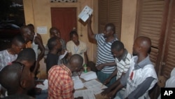Le personnel électoral dépouillant les votes après la clôture du scrutin, à un bureau de vote à Conakry, en Guinée, le 28 septembre 2013.