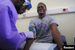 The blood of a survivor of the Ebola virus is extracted as part of a study launched at Liberia's John F. Kennedy Hospital in Monrovia, Liberia, June 17, 2015.